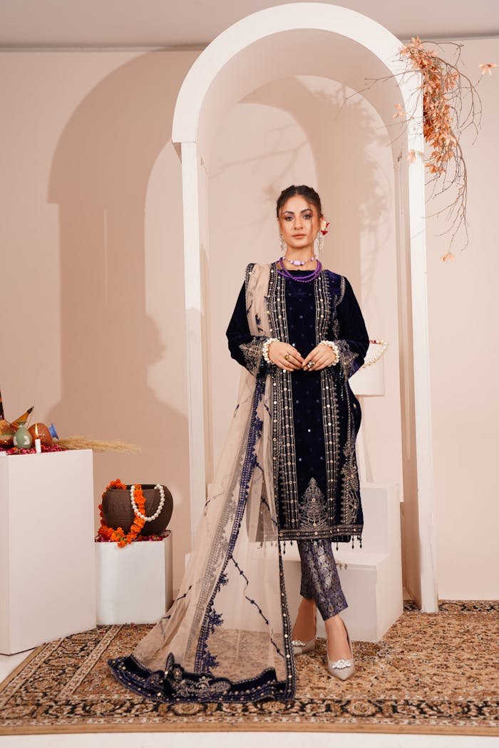 A fashionable woman posing indoors in traditional attire in Lahore, Pakistan.